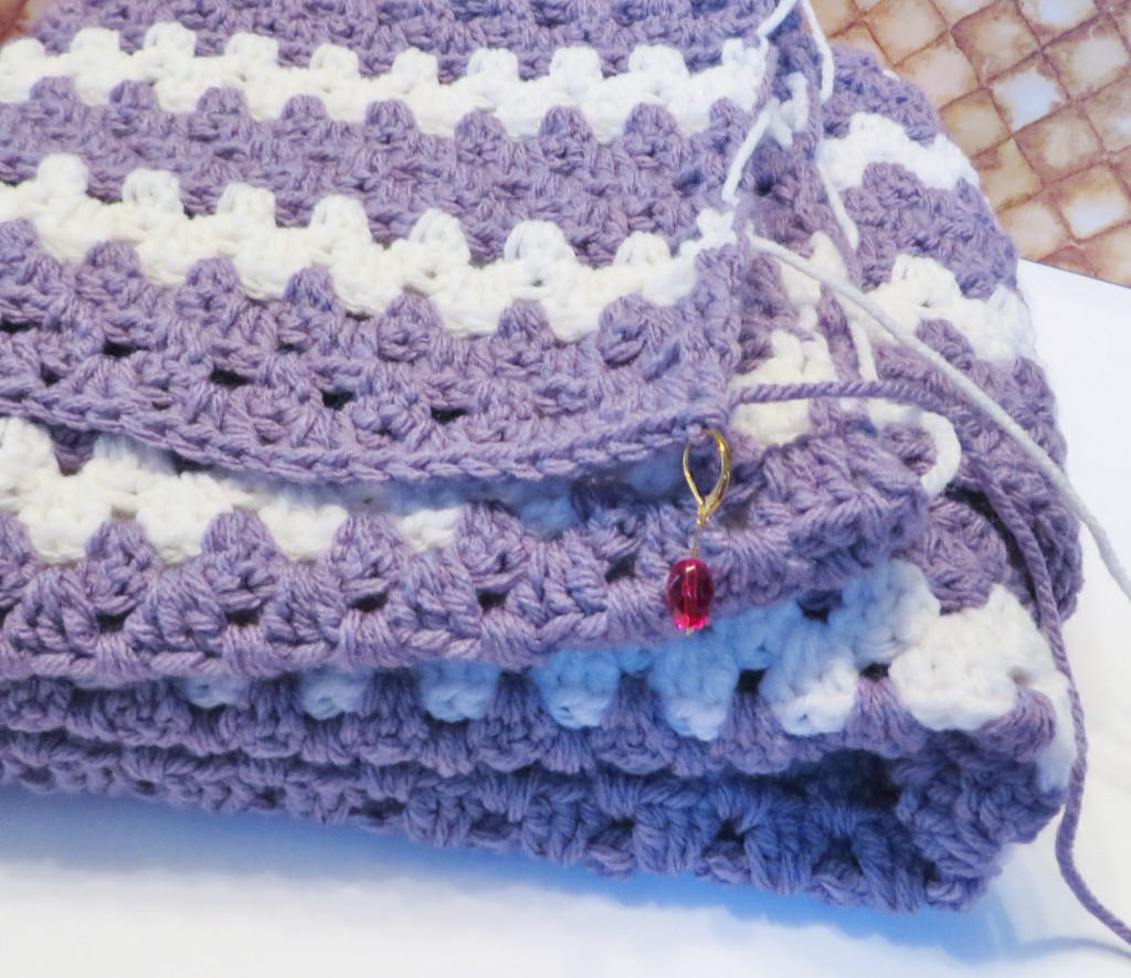 Purple and white crochet baby blanket.